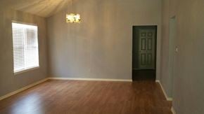 Houston house for rent - A room with a wooden floor and a black door.