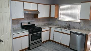 Houston house for rent - A kitchen with a stove, sink, and cabinets.
