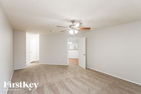 Houston house for rent - A spacious room with a ceiling fan and carpeted floor.