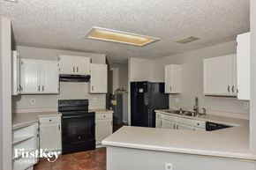 San Antonio house for rent - A kitchen with black appliances and white cabinets.
