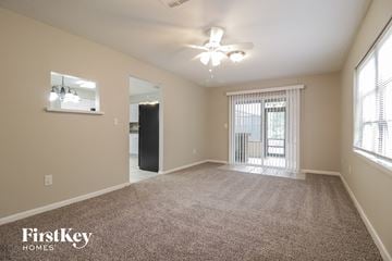 Titusville house for rent - a spacious living room with carpet and a ceiling fan