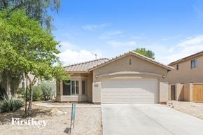 Surprise house for rent - a house with a garage door and a driveway