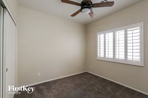Surprise house for rent - a bedroom with a ceiling fan and a window