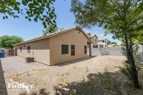 Surprise house for rent - a house with a dirt yard and trees in front of it