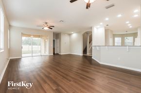 New Port Richey house for rent - A spacious room with wooden floors and a ceiling fan.