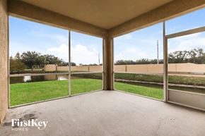 New Port Richey house for rent - A patio area with a view of a grassy field and a fence.