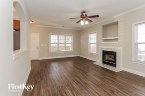 Huntersville house for rent - an empty living room with a fireplace and a ceiling fan