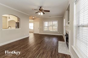 Huntersville house for rent - an empty living room with a ceiling fan and a fireplace