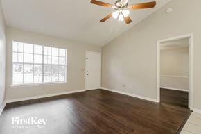 Palm Bay house for rent - an empty living room with a ceiling fan and a window