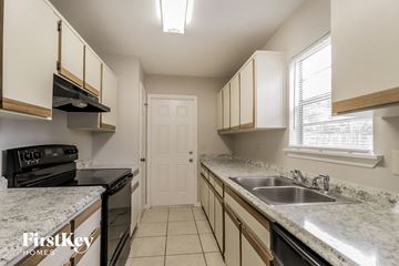 Palm Bay house for rent - a kitchen with granite counter tops and black appliances and a sink
