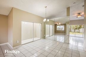 Miami house for rent - A spacious room with a tiled floor and a ceiling fan.