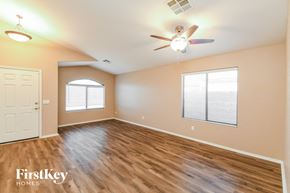 San Tan Valley house for rent - an empty living room with a ceiling fan and a window