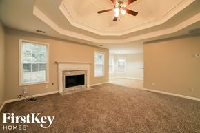 Loganville house for rent - a living room with a fireplace and a ceiling fan