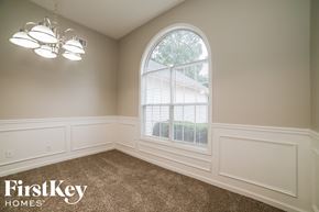 Loganville house for rent - an empty dining room with a large arched window