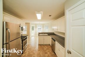 Loganville house for rent - a kitchen with stainless steel appliances and white cabinets