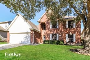Tomball house for rent - A brick house with a tree in front of it.