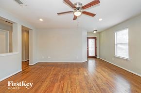 Houston house for rent - A spacious room with a ceiling fan and wooden flooring.