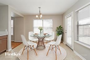 Houston house for rent - A dining room with a glass table and white chairs.