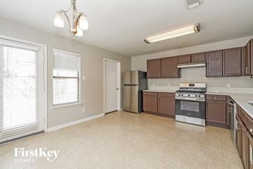 Houston house for rent - A kitchen with brown cabinets and a stainless steel refrigerator.