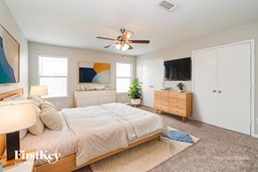 Houston house for rent - A bedroom with a bed, dresser, and ceiling fan.