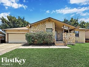 Farmers Branch house for rent - A house with a stone wall and a garage door.