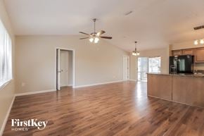 Palm Bay house for rent - A spacious room with wooden floors and a ceiling fan.