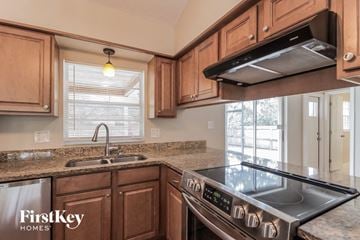 Palm Bay house for rent - A kitchen with wooden cabinets and a stainless steel stove top.