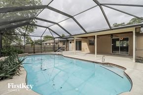 Palm Bay house for rent - A swimming pool under a glass roof in a residential area.