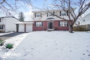 Columbus house for rent - A house with a red brick facade and a white garage door is surrounded by snow.