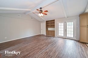 Houston house for rent - A spacious room with wooden flooring and a ceiling fan.