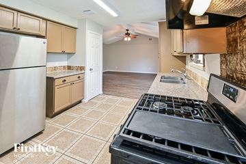 Houston house for rent - A kitchen with a stove top oven and a refrigerator.