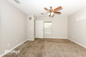 Port St. Lucie house for rent - A spacious room with a ceiling fan and carpeted floor.
