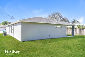 Port St. Lucie house for rent - A small white building with a FirstKey HOMES sign on the lawn.