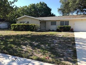 Fort Myers house for rent - a small white house with a lawn in front of it