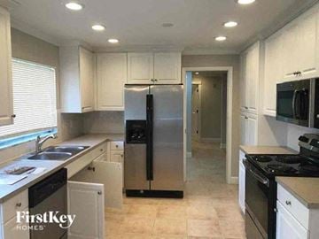 Fort Myers house for rent - a kitchen with a stainless steel refrigerator and a sink