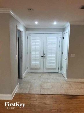 Fort Myers house for rent - a hallway with white doors and a tiled floor