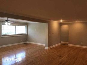 Fort Myers house for rent - an empty living room with a ceiling fan and a window