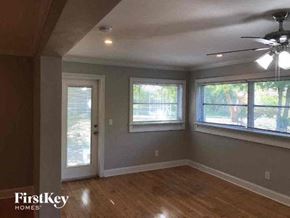 Fort Myers house for rent - an empty living room with a ceiling fan and three windows