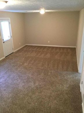 Jonesboro house for rent - A room with a carpeted floor and a door.