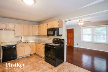 Grandview house for rent - A kitchen with wooden cabinets and black appliances.