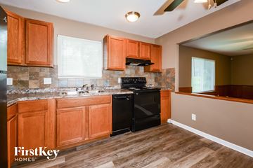 Florissant house for rent - a kitchen with black appliances and wooden cabinets