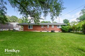 Florissant house for rent - a red brick house with a large yard and green grass