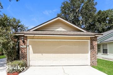 Jacksonville house for rent - a white garage door in front of a brick house