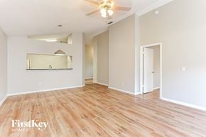 Jacksonville house for rent - the living room and dining room with wood flooring and a ceiling fan