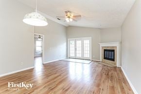 Jacksonville house for rent - an empty living room with a fireplace and wooden floors
