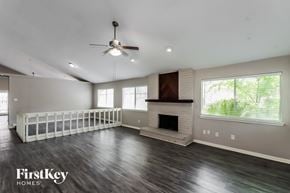 Houston house for rent - A spacious living room with a fireplace and a ceiling fan.