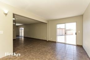 Glendale house for rent - A spacious room with tiled flooring and a sliding glass door leading outside.