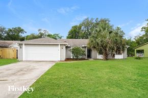 Deltona house for rent - a white house with a palm tree in front of a lawn
