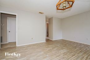 Deltona house for rent - the living room and dining room with wood flooring and a chandelier