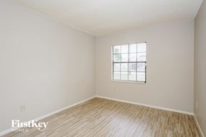 Deltona house for rent - a bedroom with wood floors and white walls and a window
